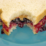 a peanut butter and jelly sandwhich that has been bitten into.