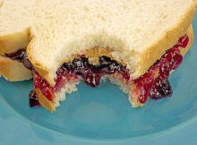 a peanut butter and jelly sandwhich that has been bitten into.